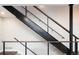A modern staircase is featured with wood handrails and metal cable railings with a metal center beam at 2978 Osceola St, Denver, CO 80212