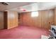 Spacious basement with wood-paneled walls, featuring a vintage stove and built-in shelving at 5935 Blanca Ct, Golden, CO 80403