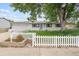 Charming single-story home with a white picket fence and solar panels on the roof at 5935 Blanca Ct, Golden, CO 80403