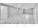 Large finished basement with white tile floors and neutral gray walls at 2971 S Sheridan Blvd, Denver, CO 80227