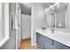 Modern bathroom with updated vanity, white countertop, blue cabinetry, modern faucet and open doorway at 2971 S Sheridan Blvd, Denver, CO 80227