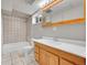 Bathroom features vanity with drawers and mirror, combined shower and bathtub, and tile surround at 2971 S Sheridan Blvd, Denver, CO 80227