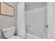 This is a bathtub and toilet with a shower curtain and decorative art piece on the wall at 2971 S Sheridan Blvd, Denver, CO 80227