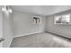 The bedroom boasts neutral walls, plush gray carpet, and two double hung windows allowing ample natural light at 2971 S Sheridan Blvd, Denver, CO 80227