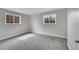 The bedroom has neutral walls, plush gray carpet, and two double hung windows providing natural light at 2971 S Sheridan Blvd, Denver, CO 80227