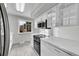 Bright kitchen featuring white cabinets, countertops, and stainless steel microwave and stove at 2971 S Sheridan Blvd, Denver, CO 80227