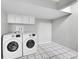 Modern laundry room featuring a Samsung washer and dryer set and convenient overhead storage cabinets at 2971 S Sheridan Blvd, Denver, CO 80227