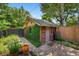 Brick backyard shed surrounded by lush landscaping and a paved walkway at 836 Steele St, Denver, CO 80206