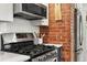 Modern kitchen with stainless steel appliances, brick accent wall, and ample counter space for culinary enthusiasts at 836 Steele St, Denver, CO 80206