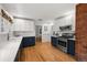 Spacious kitchen featuring custom cabinets, stainless steel appliances, quartz countertops, and exposed brick at 836 Steele St, Denver, CO 80206