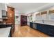 Stylish kitchen featuring custom cabinets, stainless steel appliances, exposed brick, and hardwood floors at 836 Steele St, Denver, CO 80206