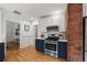 Well-equipped kitchen featuring custom cabinets, stainless steel appliances, quartz countertops and exposed brick at 836 Steele St, Denver, CO 80206
