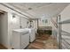 Functional laundry room with washer, dryer, vintage sink, and metal storage shelves for organized convenience at 836 Steele St, Denver, CO 80206