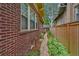 Brick walkway along side of house lined with lush greenery and privacy fence at 836 Steele St, Denver, CO 80206
