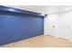 Finished basement with blue accent wall, wood-look floors, and white doors at 2655 S Humboldt St, Denver, CO 80210