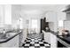 Modern kitchen with white cabinetry, granite countertops, and a black-and-white checkered floor at 2655 S Humboldt St, Denver, CO 80210
