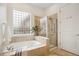 Bright bathroom featuring a soaking tub with tile surround and glass enclosed shower stall at 2100 N Humboldt St # 302, Denver, CO 80205