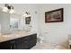 Bathroom featuring double sinks with dark cabinetry, decorative art and standard toilet at 2100 N Humboldt St # 302, Denver, CO 80205