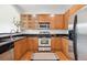 Well-lit kitchen featuring stainless steel appliances, wooden cabinets, and granite countertops at 2100 N Humboldt St # 302, Denver, CO 80205