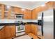 Bright kitchen boasts stainless steel appliances, wooden cabinets, and sleek black countertops at 2100 N Humboldt St # 302, Denver, CO 80205