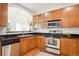 Well-lit kitchen featuring wooden cabinets, stainless steel appliances, and dark countertops at 2100 N Humboldt St # 302, Denver, CO 80205