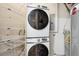 Laundry room with front loading Samsung washer and dryer and wire racks for additional storage at 2100 N Humboldt St # 302, Denver, CO 80205