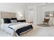 Bright main bedroom featuring a tufted headboard, bedside table, and decoratively-placed accent chair at 2100 N Humboldt St # 302, Denver, CO 80205