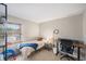 Simple bedroom with bed, chair, and desk area with shelving at 6937 S Knolls Way, Centennial, CO 80122