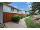A pleasant side exterior view shows a walkway bordered by grass and rockwork leading to the home at 6937 S Knolls Way, Centennial, CO 80122