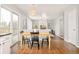 Sunlit dining room with wood floors and a view of the living room is an entertainer's dream at 10063 Silver Maple Rd, Highlands Ranch, CO 80129