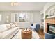 Bright living room with fireplace, shutters, and hardwood flooring provides a welcoming ambiance at 10063 Silver Maple Rd, Highlands Ranch, CO 80129