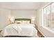 Inviting main bedroom featuring plush bedding, wood floors, and bright, shuttered window at 10063 Silver Maple Rd, Highlands Ranch, CO 80129