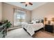 Comfortable bedroom featuring carpet flooring, a ceiling fan and a window with curtains at 12715 Madison St, Thornton, CO 80241