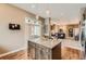 Kitchen island with barstool seating and granite counters flows into living room with great natural light at 12715 Madison St, Thornton, CO 80241