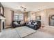 Bright living room featuring plush seating, a stylish ceiling fan, and ample natural light at 12715 Madison St, Thornton, CO 80241