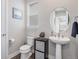 Charming half bathroom with pedestal sink, oval mirror, and stylish decor at 6733 S Waterloo Ct, Aurora, CO 80016