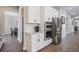 Modern kitchen with stainless steel appliances, white cabinets, and hardwood floors. Adjacent pantry and dining area at 6733 S Waterloo Ct, Aurora, CO 80016