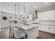 Bright kitchen features a large island, white cabinets, stainless steel appliances, and modern pendant lighting at 6733 S Waterloo Ct, Aurora, CO 80016