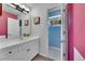 Cozy bathroom with a white vanity, a mirror, and an adjacent powder room at 6681 Flintwood Rd, Parker, CO 80138