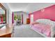 Bright bedroom with a pink accent wall, a chandelier, and built-in closet at 6681 Flintwood Rd, Parker, CO 80138