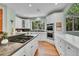 Kitchen featuring an island cooktop, stainless steel appliances, and granite countertops with forest views at 6681 Flintwood Rd, Parker, CO 80138