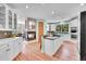 Bright, open kitchen with an island, wooden floors, granite countertops, and a fireplace at 6681 Flintwood Rd, Parker, CO 80138