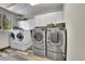 Spacious laundry room with abundant cabinets, modern washer and dryers, and window views at 6681 Flintwood Rd, Parker, CO 80138