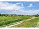 Expansive view of the property with a dirt road running through a grassy field at 6681 Flintwood Rd, Parker, CO 80138