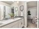 Double vanity bathroom with modern fixtures and a view of a bedroom at 15792 E Otero Cir, Centennial, CO 80112