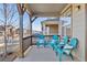 Covered porch with teal chairs and cushions, offering a relaxing outdoor space at 15792 E Otero Cir, Centennial, CO 80112