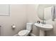 Clean powder room with pedestal sink, toilet and oval mirror at 15792 E Otero Cir, Centennial, CO 80112