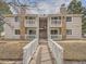 Inviting exterior of multi-Gathering home with stone accents and charming white bridge walkway at 14131 E Jewell Ave # 104, Aurora, CO 80012