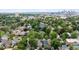 Expansive aerial view of a neighborhood with lush trees and the city skyline in the background at 2975 Irving St, Denver, CO 80211