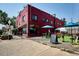 Exterior view of a red brick building with outdoor patio seating and blue umbrellas at 2975 Irving St, Denver, CO 80211